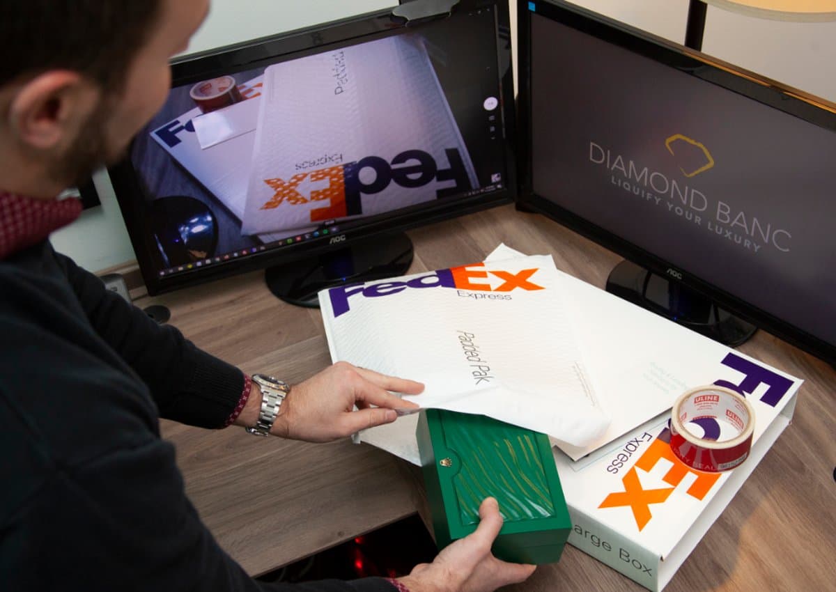 A Diamond Banc team member packing a jewelry box into insured FedEx Express shipping envelopes